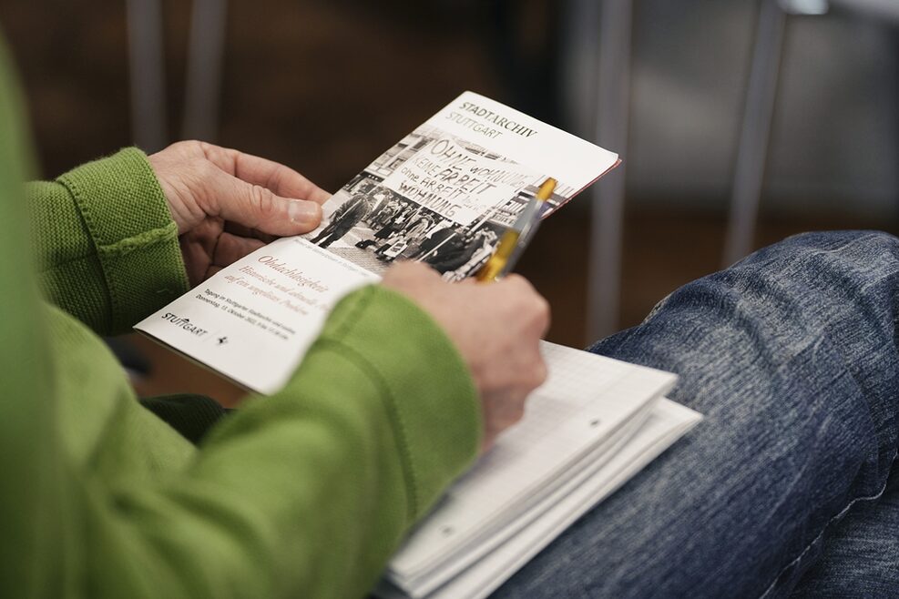 Zwei Hände halten einen Flyer zum Thema Obdachlosigkeit.