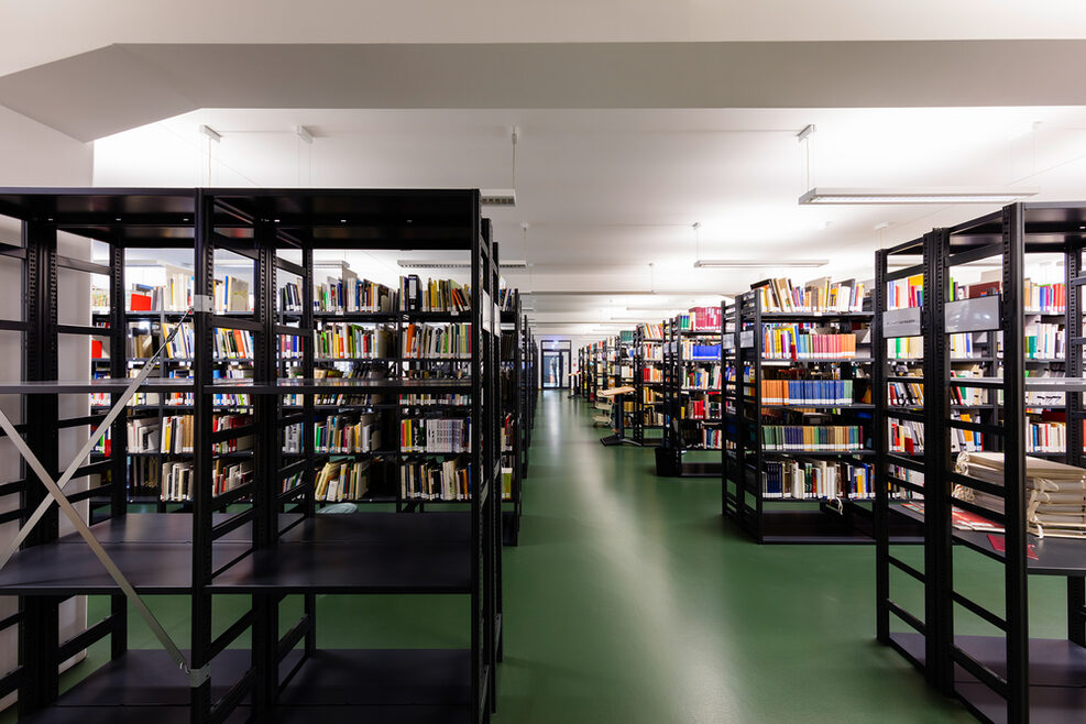 Bibliothek mit Regalen voller Bücher.