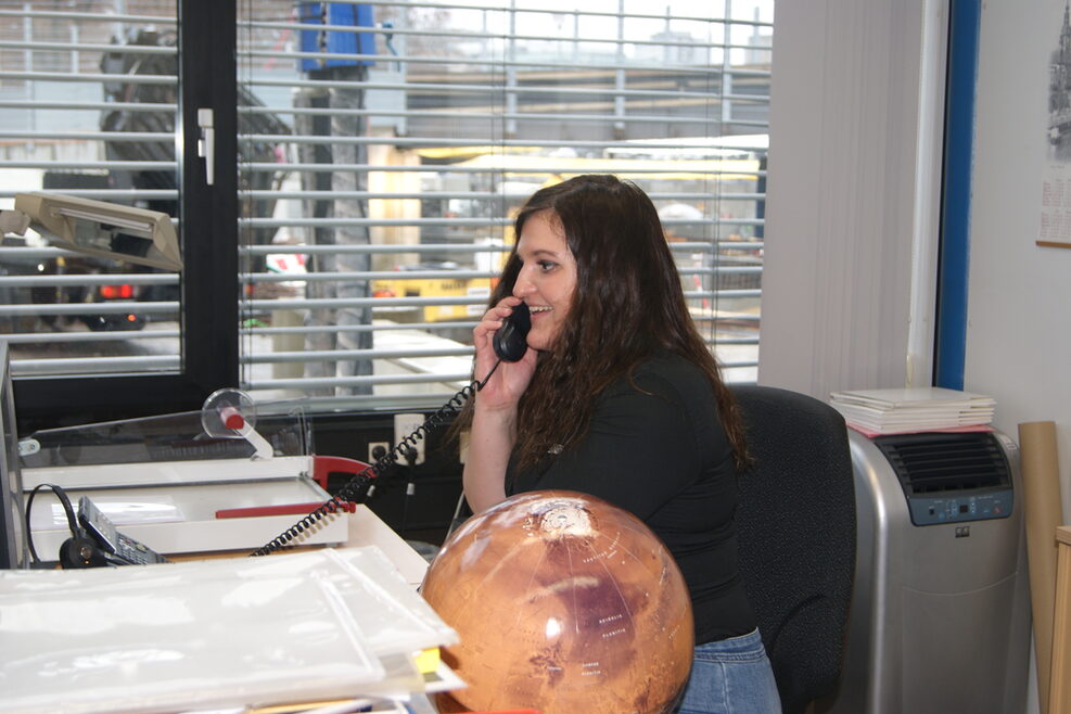 Verwaltungsmitarbeiterin im Planetarium beim Telefonieren