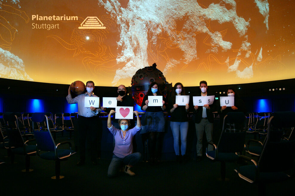 Das Team des Planetariums mit Schild "We miss u"