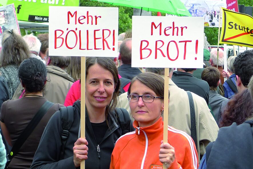 Die Künstlerinnen mit Plakaten "Mehr Böller!", "Mehr Brot!"