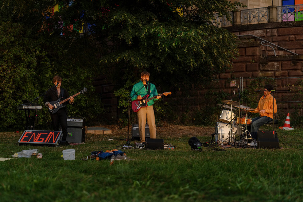 Die drei Mitglieder der Band ENGIN treten im Park der Villa Berg im Rahmen eines Picknickkonzerts auf.