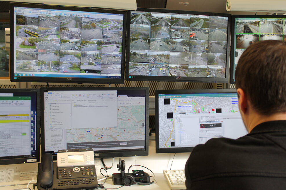 Ein Mitarbeiter der Verkehrsleitzentrale sitzt vor mehreren Bildschirmen.