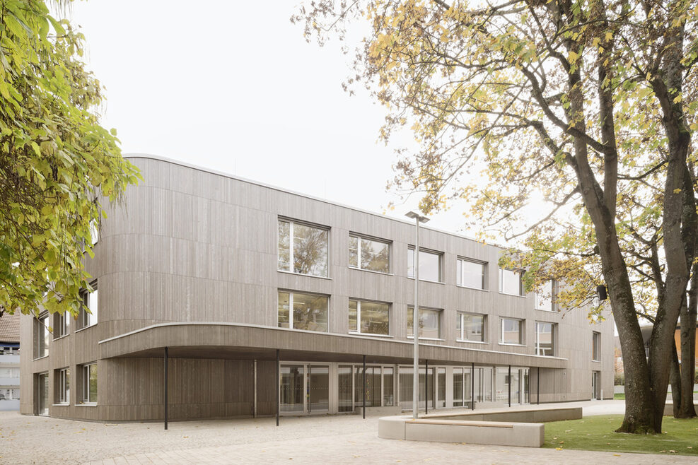 Blick von Nordwest auf die Westfassade - Überdachter Haupteingang mit Ganztagesräumen im EG und Klassenzimmern in den Obergeschossen