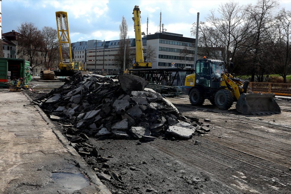 Zu sehen sind Reste des ausgefrästen Asphalts auf der Rosensteinbrücke, ein Bagger sowie zwei Kräne.