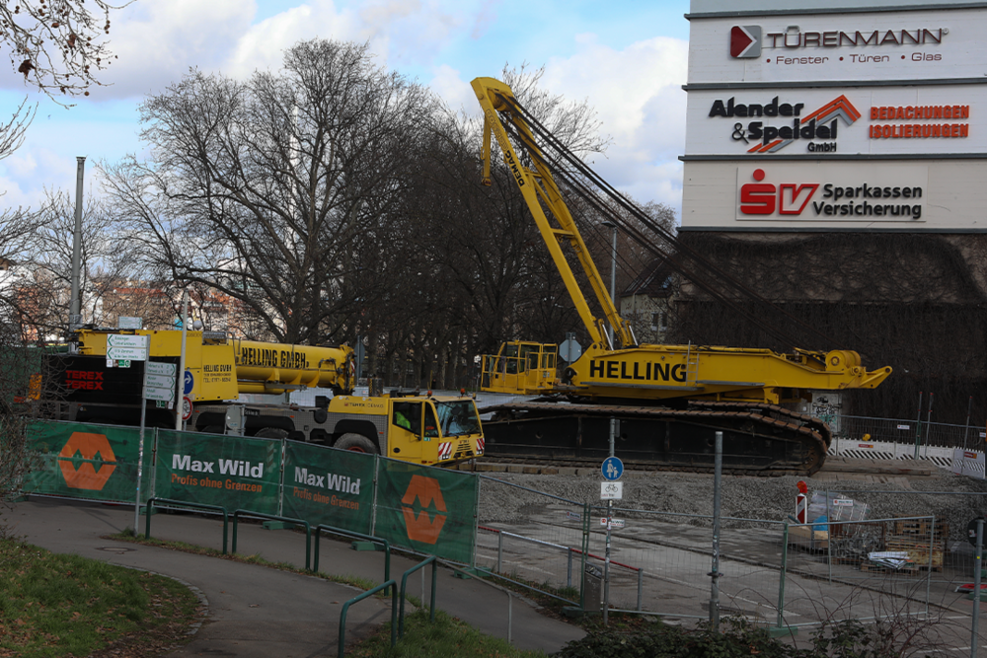 Der untere Teil des Raupenkrans und ein Spezialtransport mit weiteren Bauteilen des Krans steht vor dem Hochbunker in Bad-Cannstatt.