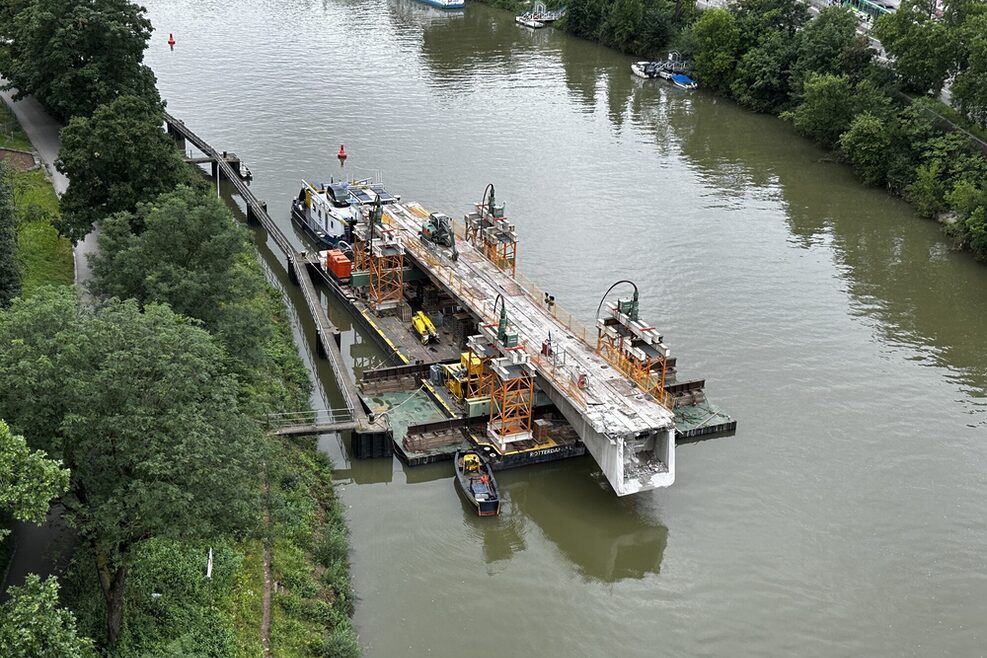 Ein Teilstück des Brückenträgers liegt auf einer schwimmenden Arbeitesplattform.