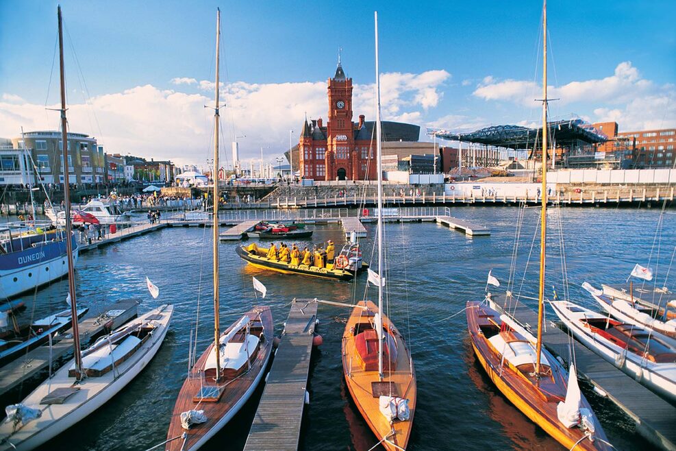 Blick auf die Cardiff Bay: Im Vordergrund liegen Boote, im Hintergrund steht das rote Pierhead Building.