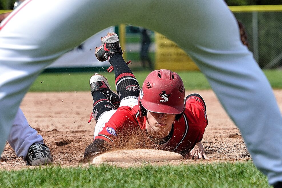 Ein Baseball-Spieler hechtet zur Base.