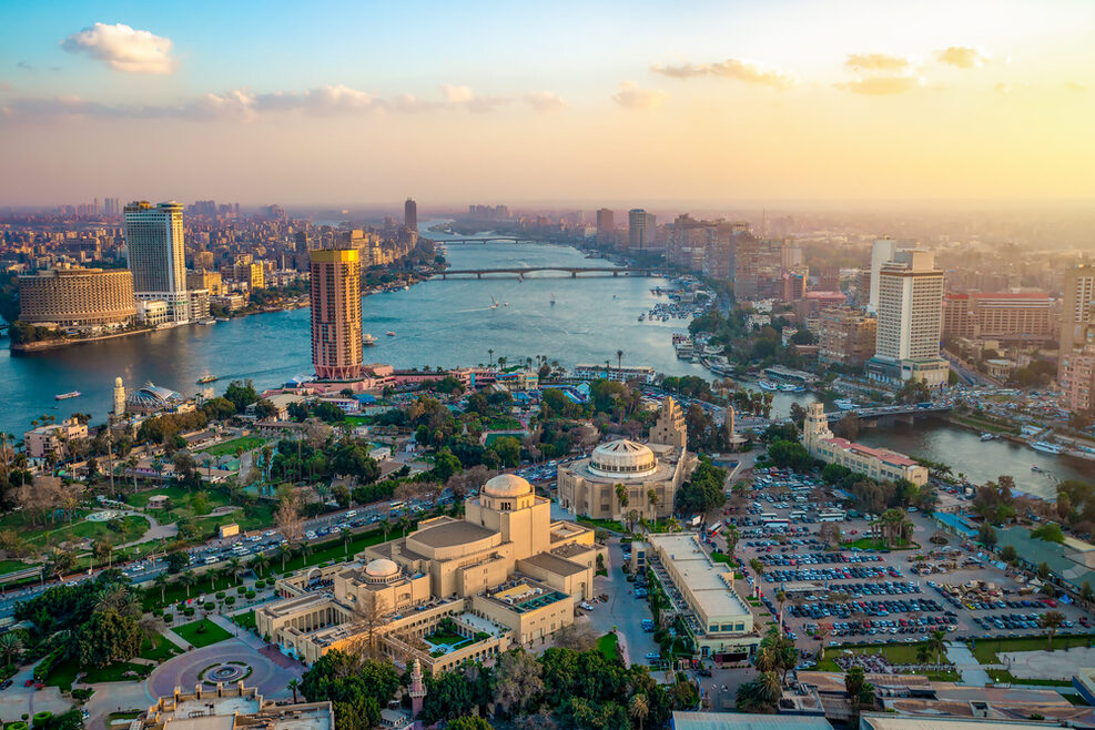 Panorama of CairoLuftaufnahme von Kairo: Ein Fluss fließt durch die Stadt, links und rechts des Ufers stehen viele Hochhäuser.