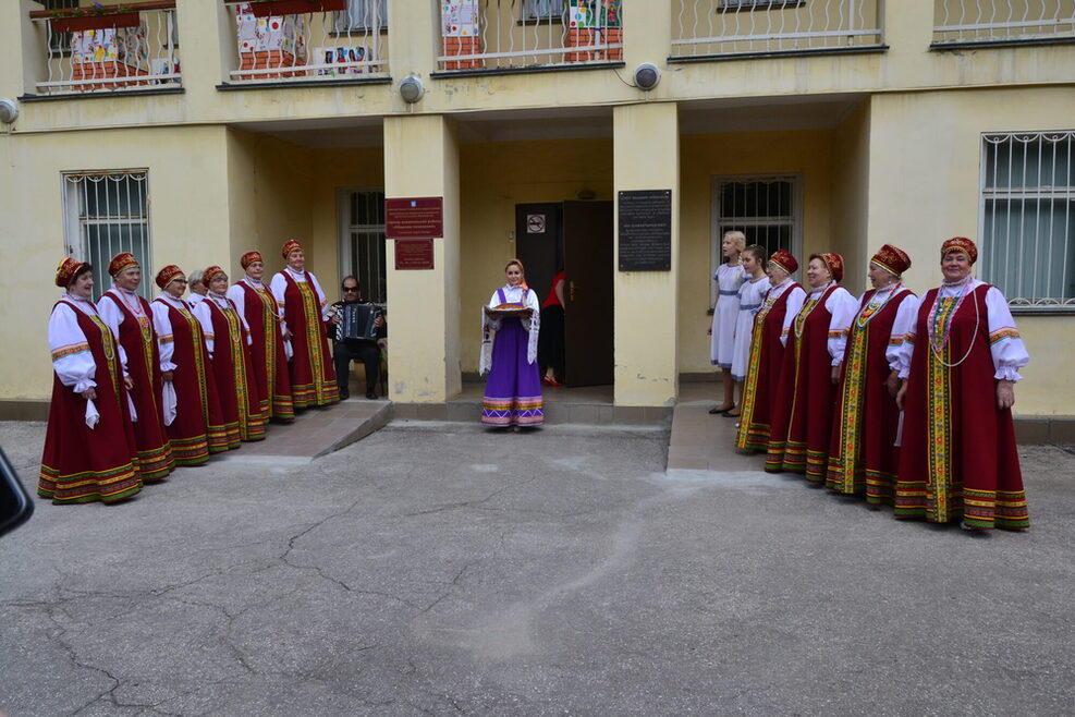 Zwei Reihen von Frauen in traditionellen Gewändern stehen Spalier.