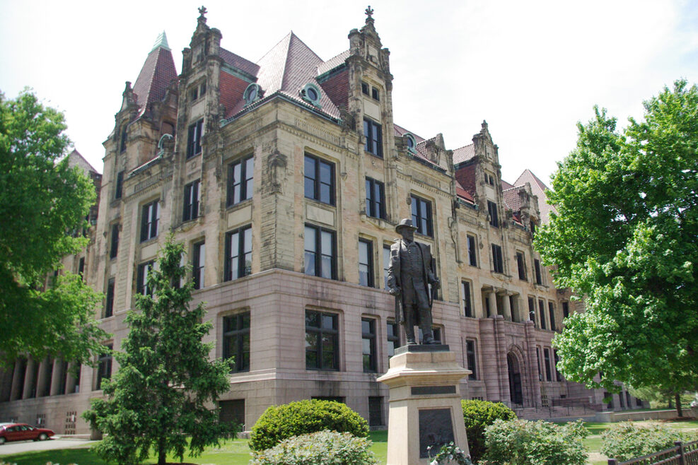 Historisches Gebäude mit einer Statue im Vordergrund