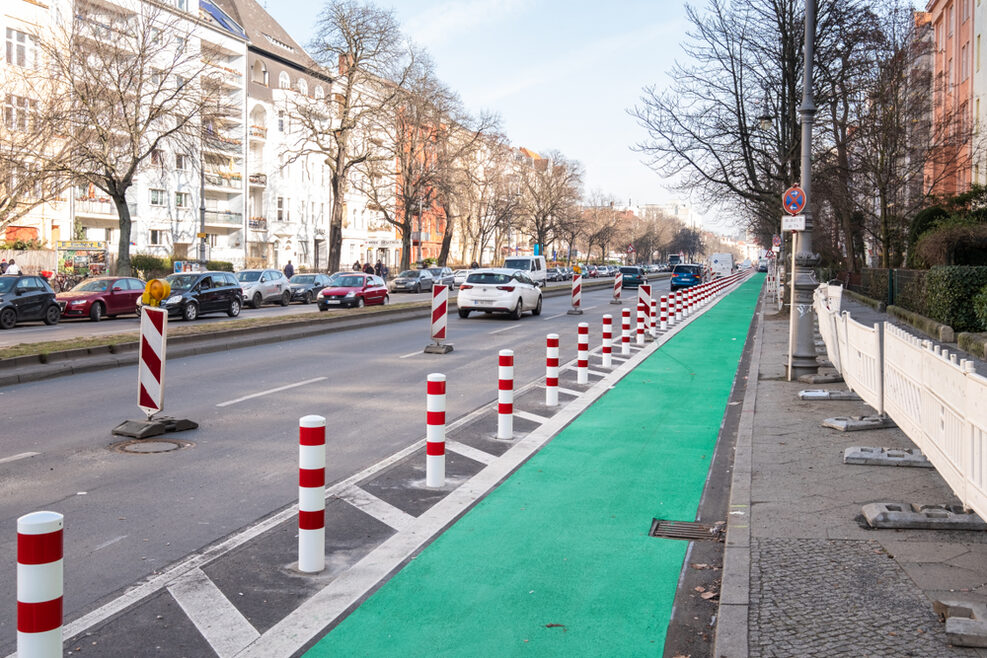 Blick auf eine Straße mit einem grünen Seitenstreifen für Radfahrer.