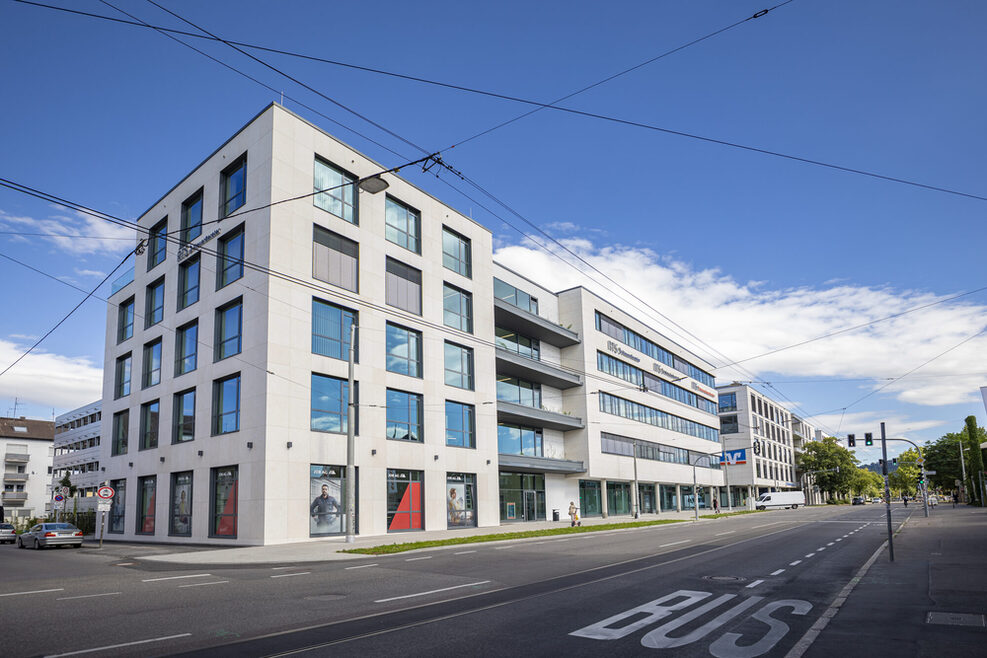 Weiße Neubauten an einer Straße.