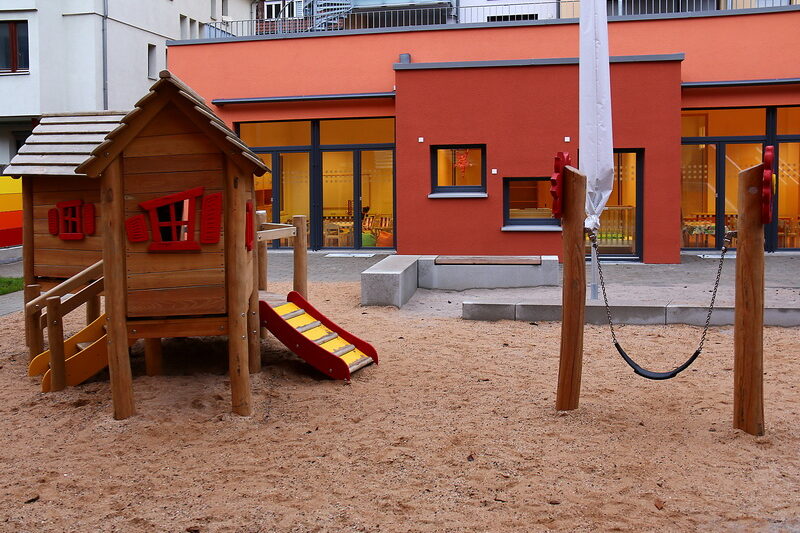 Außengelände der Reichenbachstraße mit Schaukel und Kletterhaus.