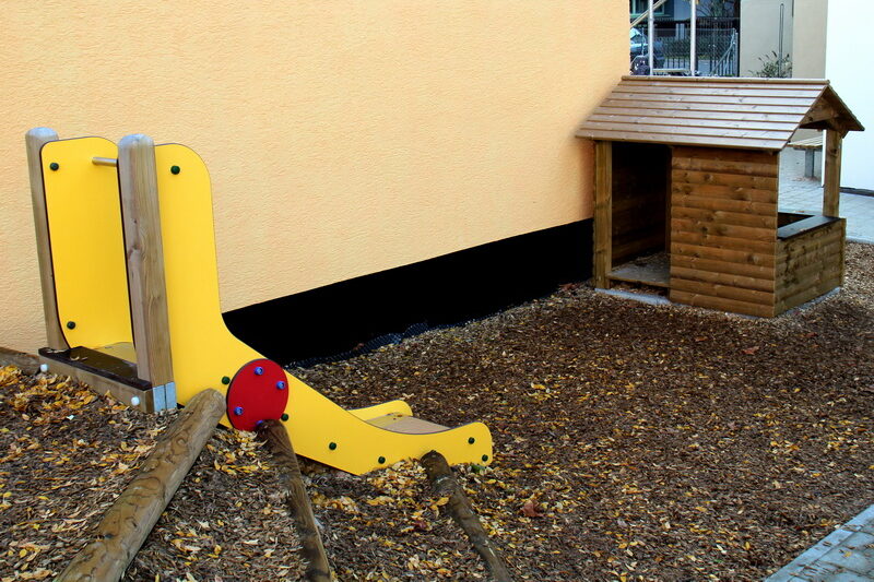 Auf dem großen Spielplatz können die Kinder im Sandkasten spielen und schaukeln.