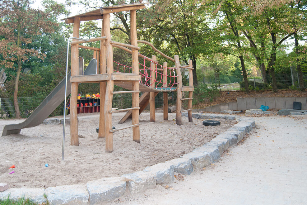 Unser schöner Abenteuerspielplatz mit Sandkasten, Kletterturm und Rutsche.