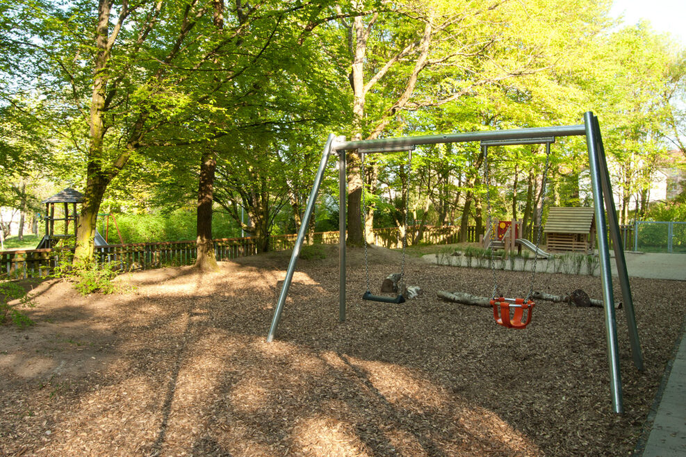 Der Garten bietet vielfältige Spielmöglichkeiten wie Schaukeln, Rutschen und Klettern.