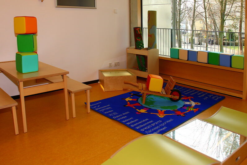 Zimmer mit Tisch, Bänken und größeren Spielwürfeln aus Schaumstoff.