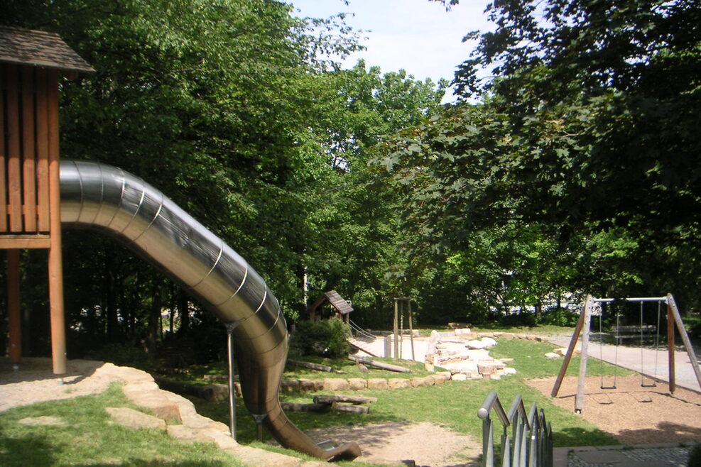 Der Spielplatz mit großer Rutsche und Schaukeln.