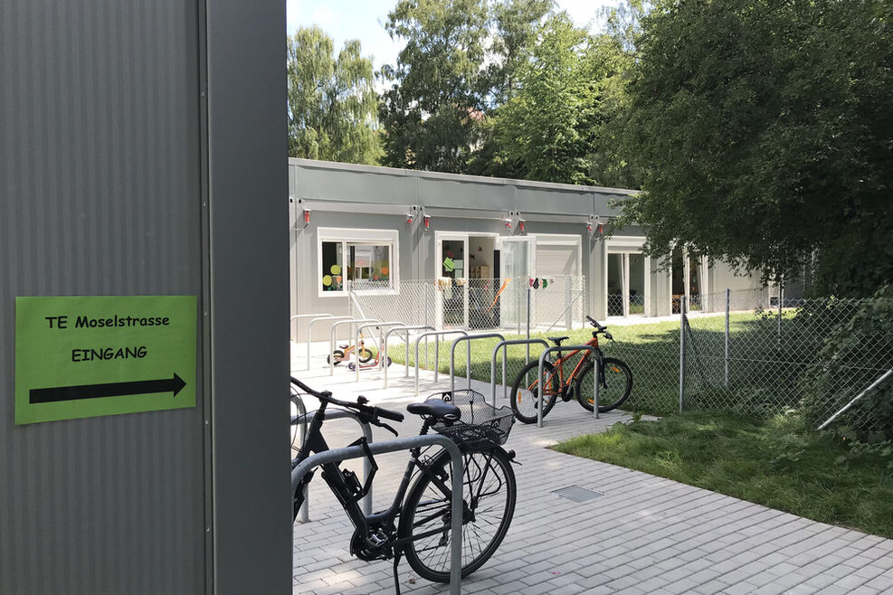 Zu sehen ist ein Fahrradstäder und der Eingang des Kifaz Moselstrasse 37.