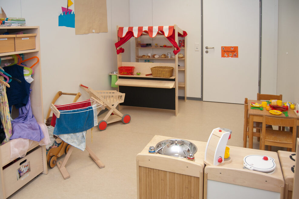 Raum mit Spielmöbeln für Kleinkinder.