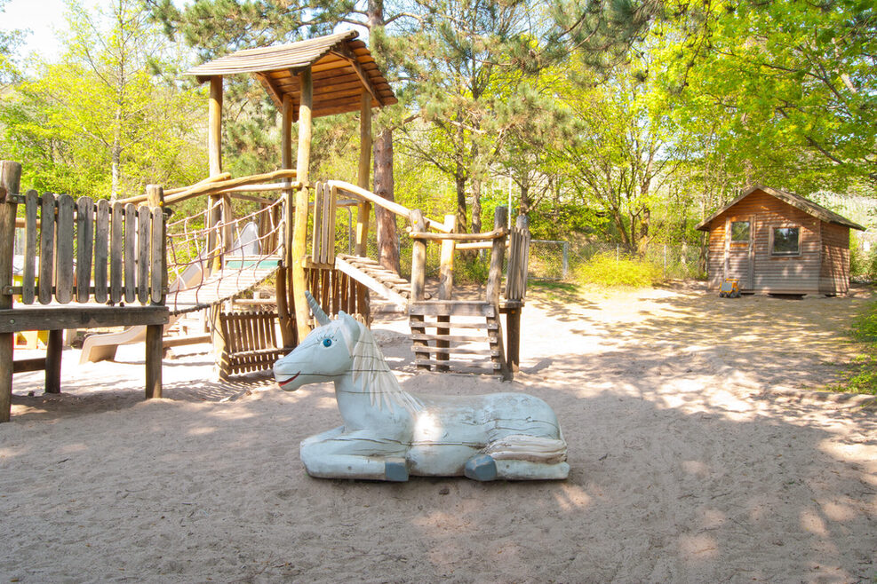 Auf dem Spielplatz gibt es viele Klettergerüste und ein Klettereinhorn.