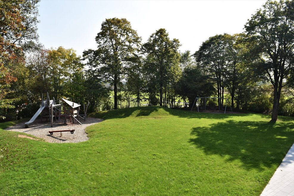 Der Spielplatz für die größeren Kinder hat ein großes Klettergerüst mit Rutsche.