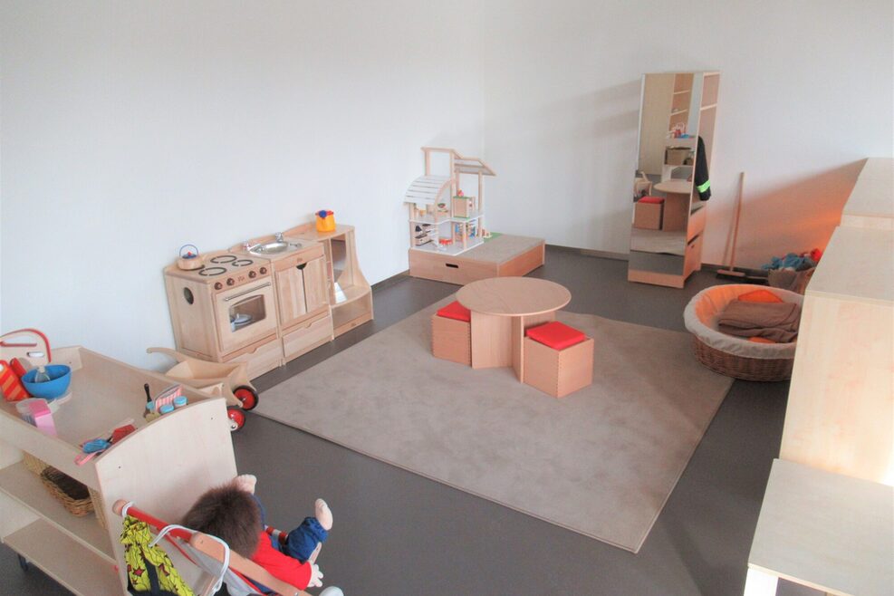 Der Rollenspielbereich ist liebevoll mit Spielküchem Puppenwagen und Puppenstube ausgestattet.