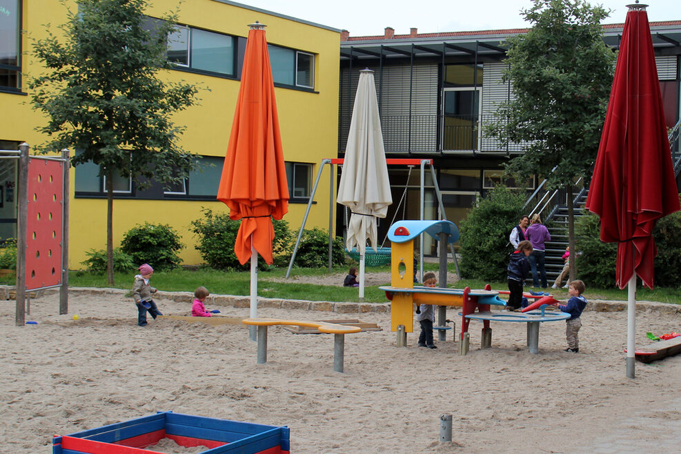 Ein großer Sandkasten mit Kletterelementen bietet viele Möglichkeiten zum Austoben an der frischen Luft.