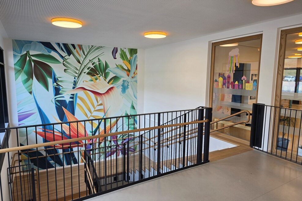 The open entrance area of the Tunzhofer Straße Children's and Family Center (KiFaZ) with a staircase leading down to the educational areas.