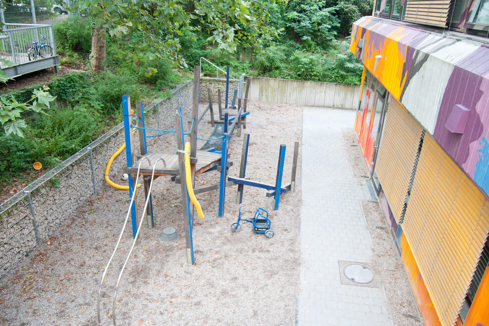 Auf dem Klettertum im Außenbereich können die Kinder an Stangen heraufklettern und ihre Balance auf der Netzbrücke trainieren.