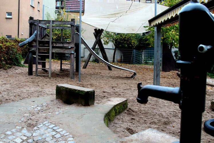 Der Spielplatz mit Klettergerüst, Rutsche und Wasserpumpe.