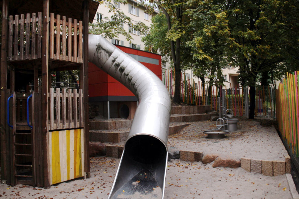 Der Spielplatz mit großer Röhrenrutsche und Drehscheiben.