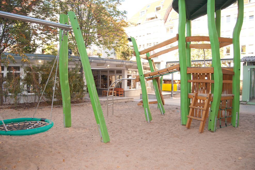 Der große Spielplatz mit Korbschaukel und Spielturm zum Klettern.