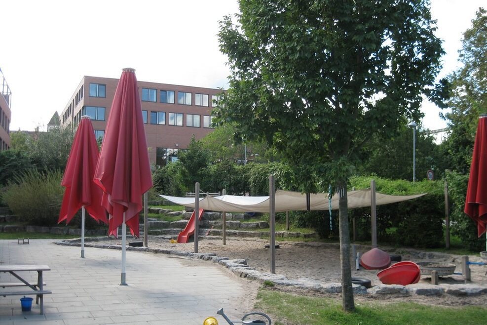 Der überdachte Sandkasten mit Rutsche und Drehkreisel zum Hineinsetzen.