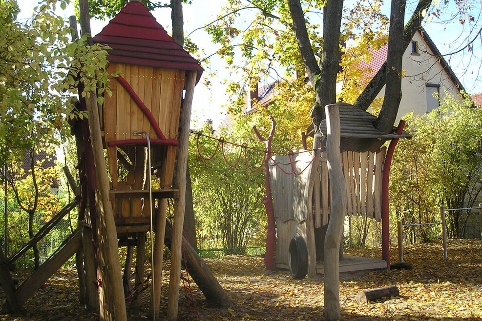 Auf dem Spielgelände steht ein großes Klettergerüst mit Reifenschaukel.