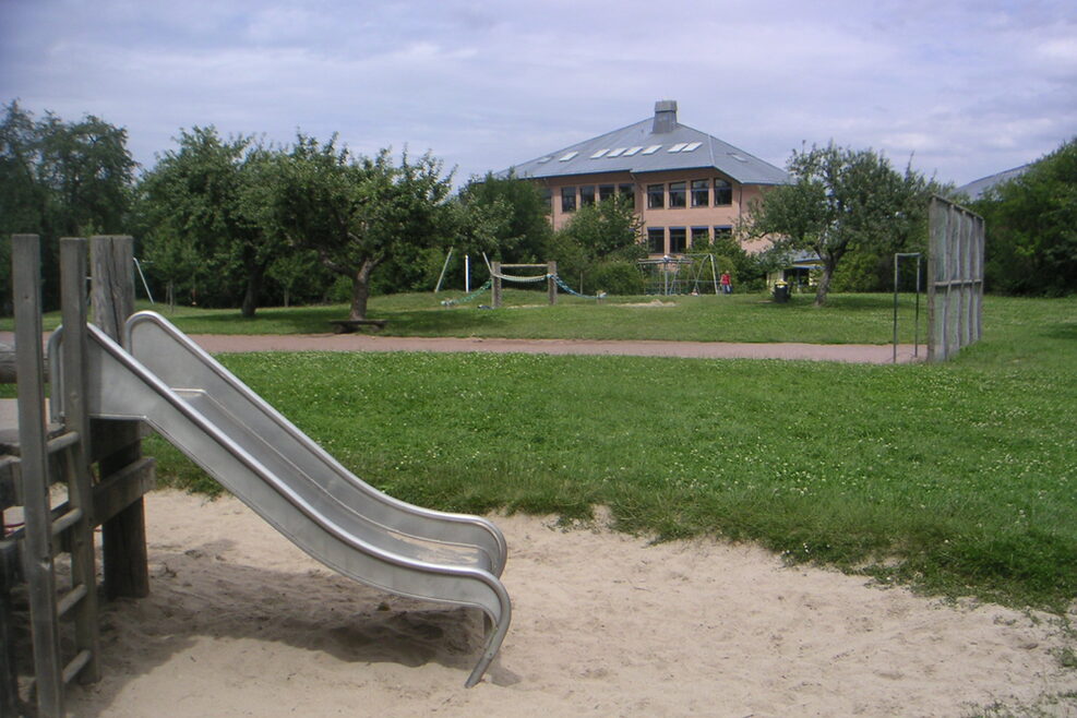 Der Spielplatz mit Klettergerüst, Rutsche und Fussballplatz.