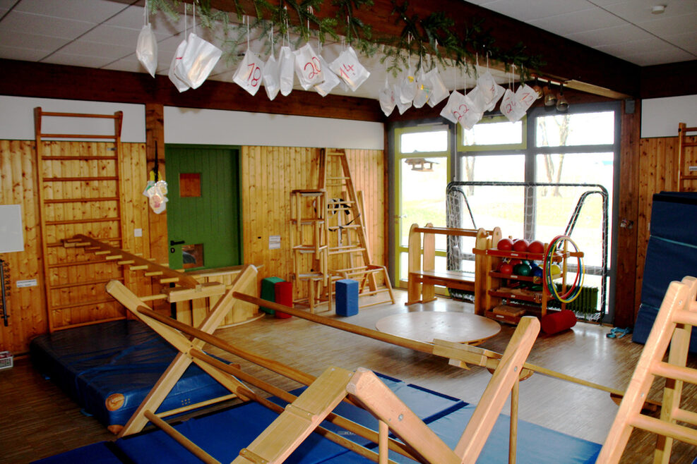 Raum mit Kletter- und Balanceelementen, Hula Hoop Reifen und Bälle für Kinder.
