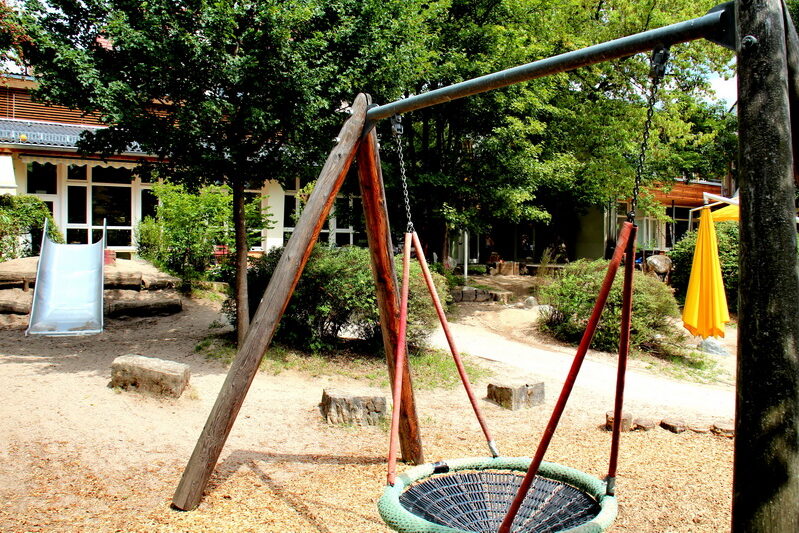 Unser Spielplatz mit Rutsche, Sandkasten und Korbschaukel.