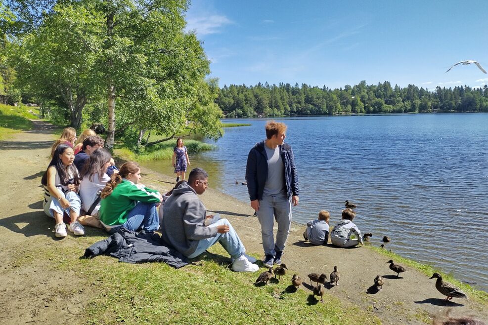 Die Jugendräte sind nach einer Wanderung erschöpft und ruhen sich am See aus.