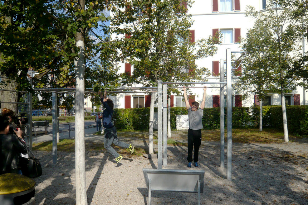 Südheimer Platz mit Calisthenics-Anlage: Jugendliche trainieren an Klimmzugstangen.