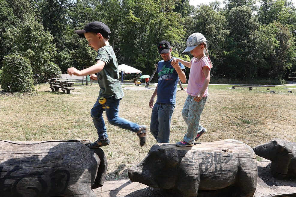 Spielende Kinder auf Schweinen aus Holz