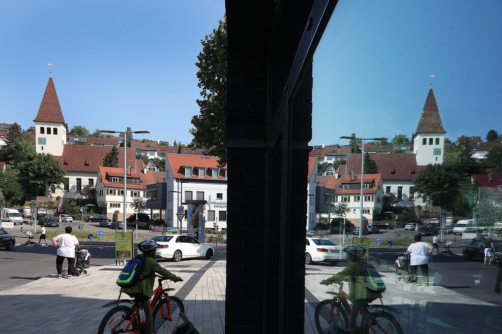 Kind mit Fahrrad in der Ortsmitte. Im Hintergrund die Auferstehungskirche.