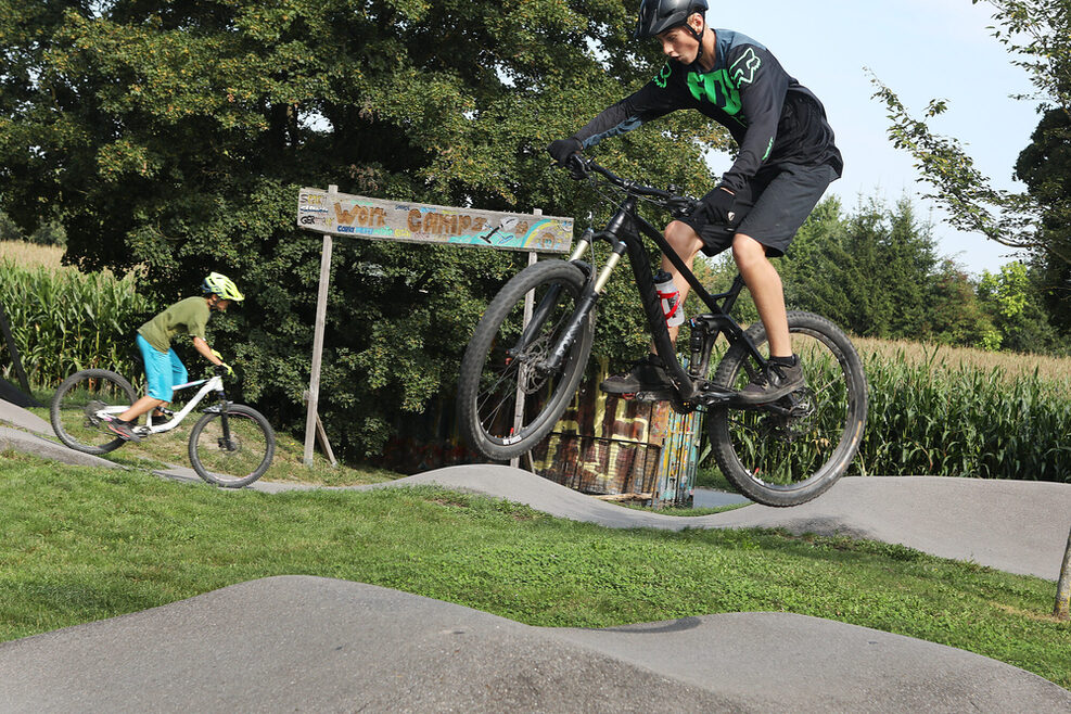 Zwei jugendliche Fahrradfahrer, die auf dem Pump-Track in Weilimforf mit ihrem Fahrrad fahren.