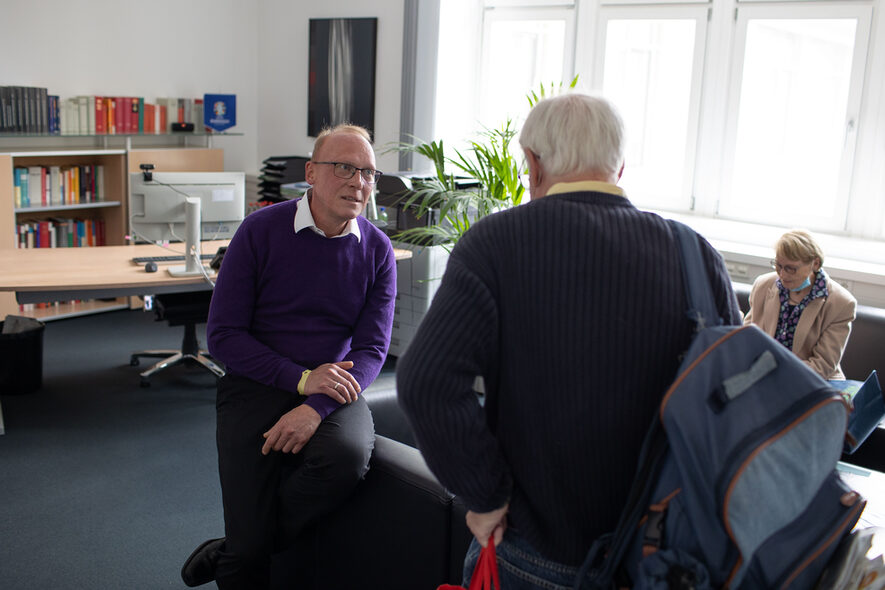 Finanzbürgermeister Thomas Fuhrmann im Gespräch mit einem Bürger in seinem Büro. Im Hintergrund sind sein Schreibtisch und eine Stitzgelegenheit zu sehen.