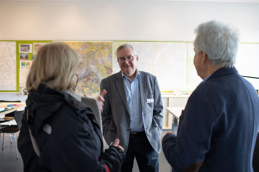 Bürgermeister Peter Pätzold unterhält sich mit besuchern in seinem Büro. Im Hintergrund sind an der Wand Karten und Pläne zu erkennen.