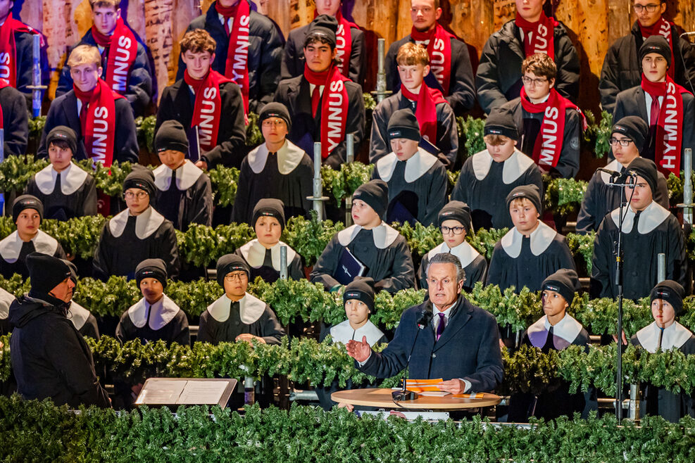 Lord Mayor Dr. Frank Nopper during his speech at the opening ceremony of the Christmas market in Stuttgart in the courtyard of the Old Palace. The boys of the Hymnus choirboys stand behind him in the rows decorated with fir trees.