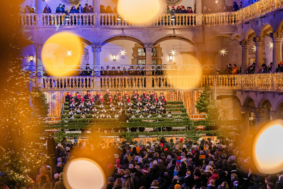 A boys' choir sings on stage at the opening ceremony of the Christmas market in the festively decorated courtyard of the Old Palace in Stuttgart.