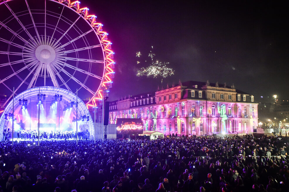 Menschenmenge vor der Bühne. Im Hintergrund Riesenrad und illumiertes Neues Schloss